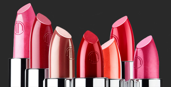multi colored lipsticks are shown against a gray background